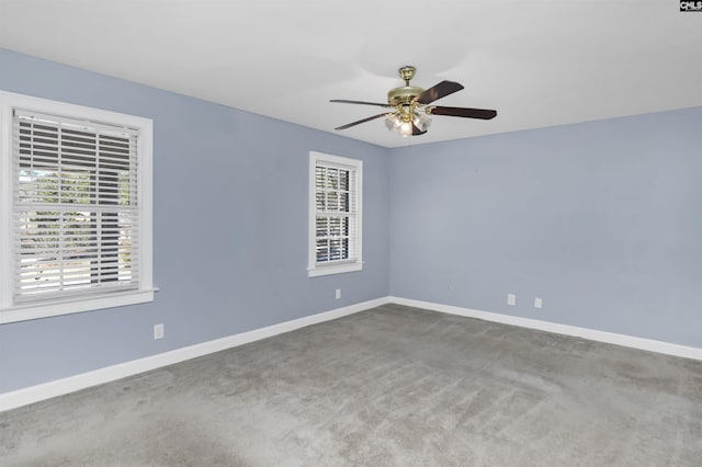 spare room featuring carpet floors, a ceiling fan, and baseboards