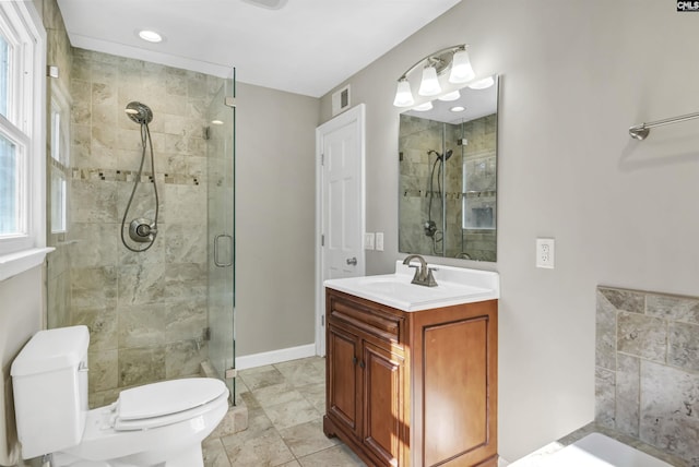 bathroom with toilet, a shower stall, baseboards, and vanity