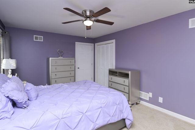 carpeted bedroom featuring a ceiling fan, visible vents, and baseboards