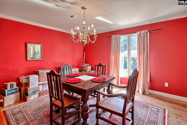 dining room with crown molding, a notable chandelier, and wood finished floors