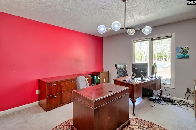 office with baseboards, a textured ceiling, and light colored carpet