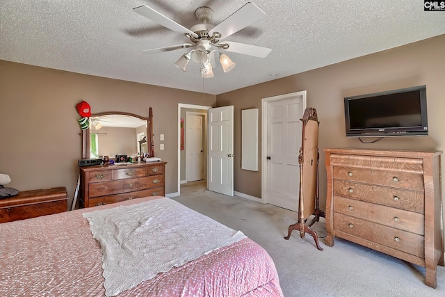 bedroom featuring light carpet, ceiling fan, a textured ceiling, and baseboards