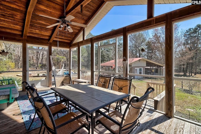 unfurnished sunroom with a ceiling fan, wood ceiling, and vaulted ceiling with beams