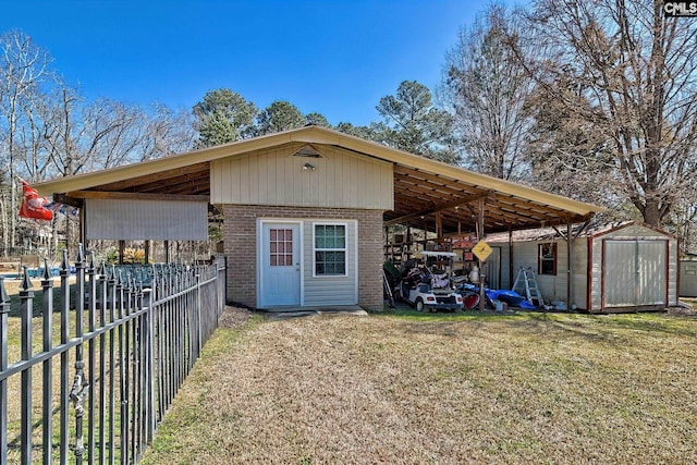 view of shed with driveway, a carport, and fence