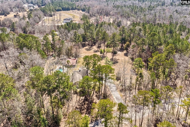 birds eye view of property featuring a forest view