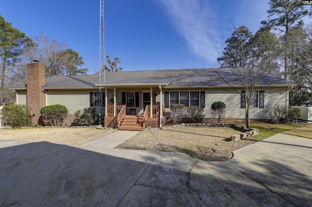 single story home with metal roof and a chimney