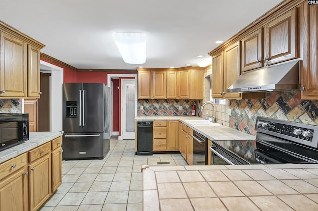 kitchen featuring stainless steel appliances, tile counters, light tile patterned flooring, a sink, and under cabinet range hood