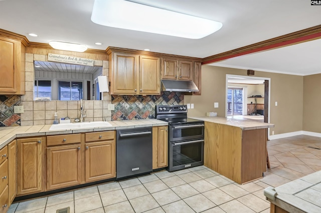 kitchen featuring range with two ovens, tile countertops, a peninsula, under cabinet range hood, and a sink