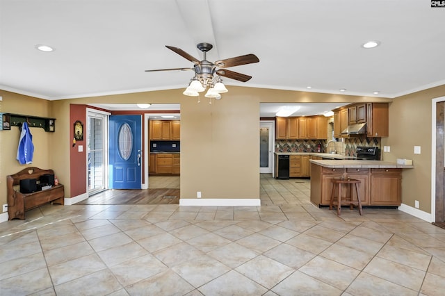 kitchen with range with electric cooktop, light countertops, crown molding, under cabinet range hood, and backsplash