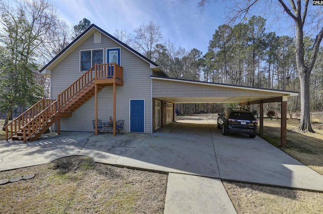 view of property exterior featuring driveway, stairway, and a carport