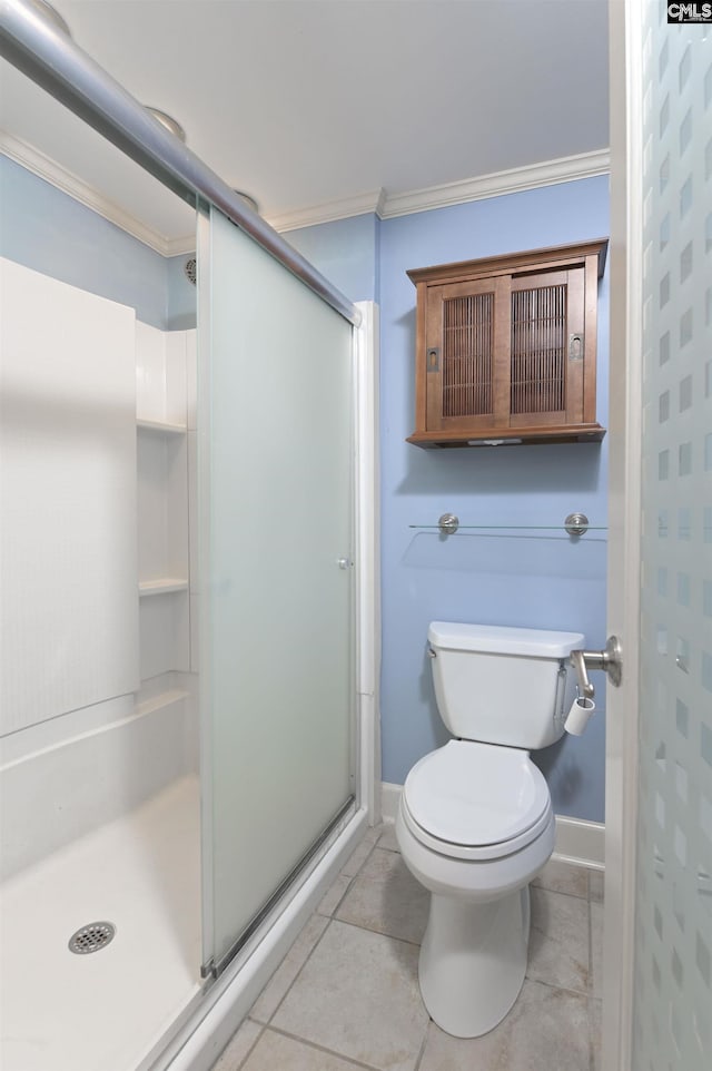 bathroom featuring ornamental molding, a stall shower, tile patterned flooring, and toilet