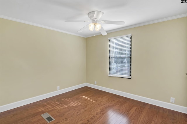 unfurnished room featuring dark wood-style flooring, crown molding, visible vents, a ceiling fan, and baseboards