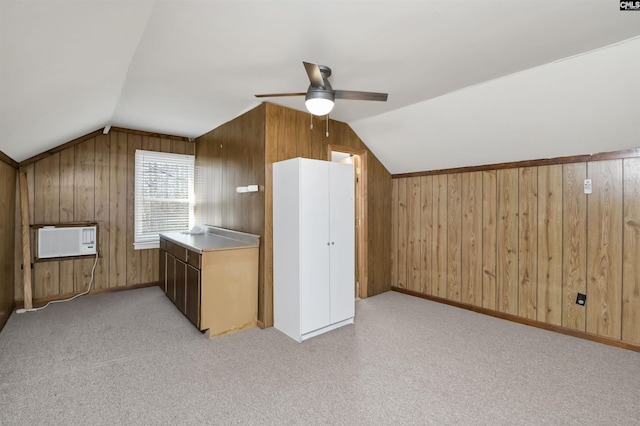 bonus room featuring lofted ceiling, ceiling fan, light carpet, and wooden walls