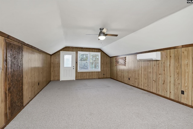 bonus room with lofted ceiling, a wall unit AC, and wood walls