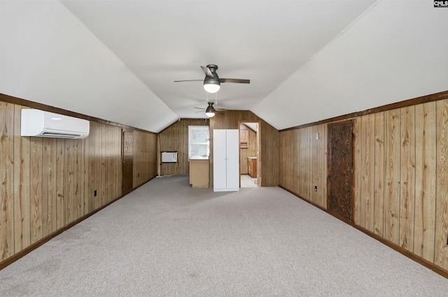 additional living space with lofted ceiling, ceiling fan, carpet floors, wood walls, and a wall mounted AC