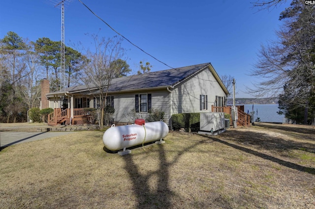 view of front of home with a water view and a front lawn