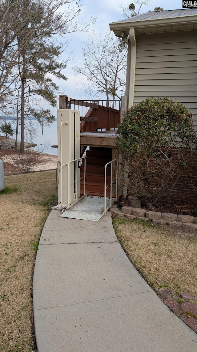 exterior space with metal roof and a lawn