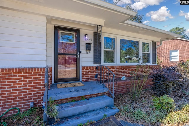 doorway to property featuring brick siding