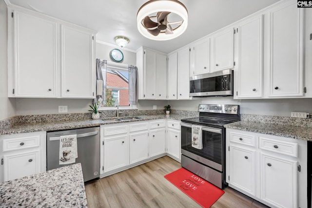 kitchen featuring white cabinetry, appliances with stainless steel finishes, and a sink