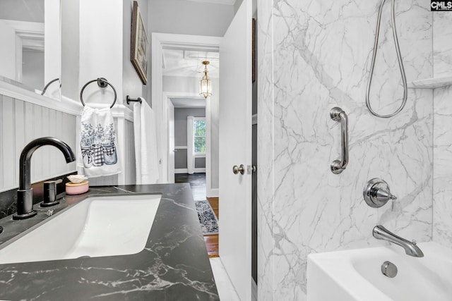 bathroom with baseboards, tub / shower combination, and vanity