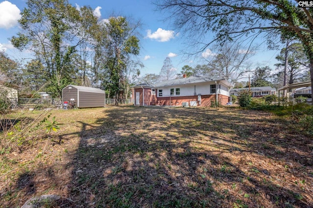 view of yard featuring a storage unit, fence, and an outdoor structure