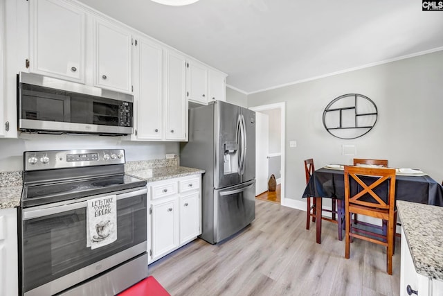 kitchen with stainless steel appliances, light wood-style floors, white cabinetry, and crown molding