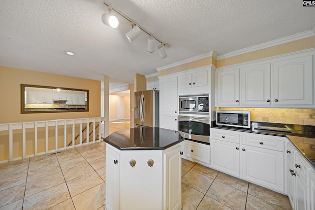 kitchen with stainless steel appliances, a kitchen island, and white cabinetry