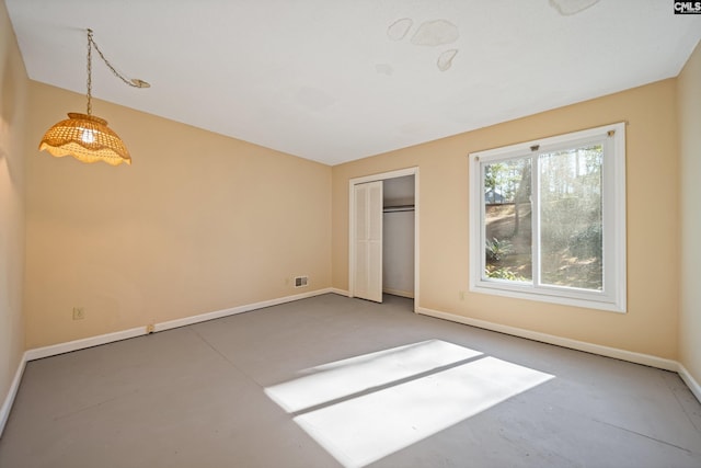 unfurnished bedroom featuring a closet, visible vents, concrete floors, and baseboards