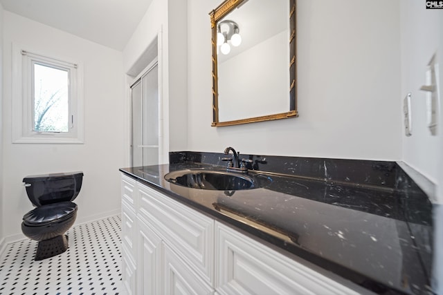 bathroom featuring toilet, tile patterned floors, baseboards, and vanity