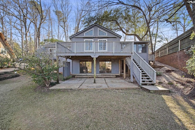 view of front facade featuring a deck, a front lawn, stairway, and a patio area