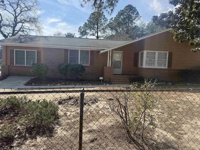 view of front of property featuring a fenced front yard, entry steps, and brick siding