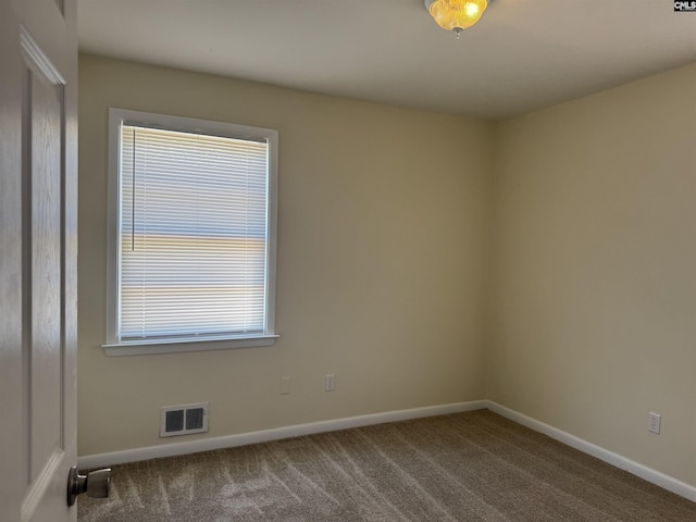 spare room with baseboards, visible vents, and carpet flooring