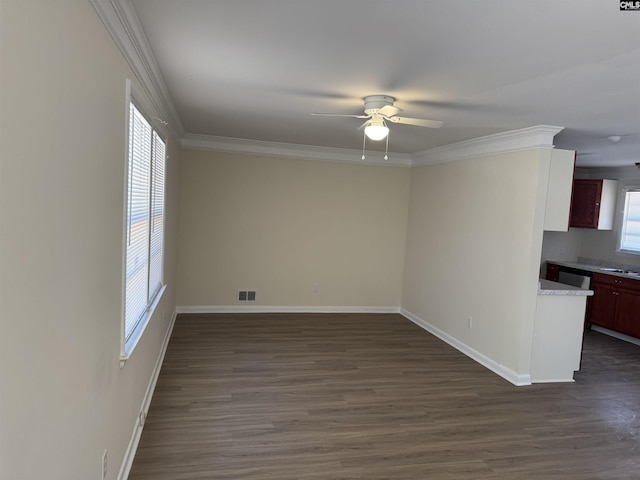 spare room featuring baseboards, dark wood finished floors, visible vents, and crown molding