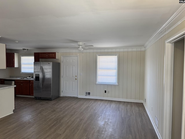 kitchen with ornamental molding, light countertops, dark wood-style flooring, and stainless steel fridge with ice dispenser