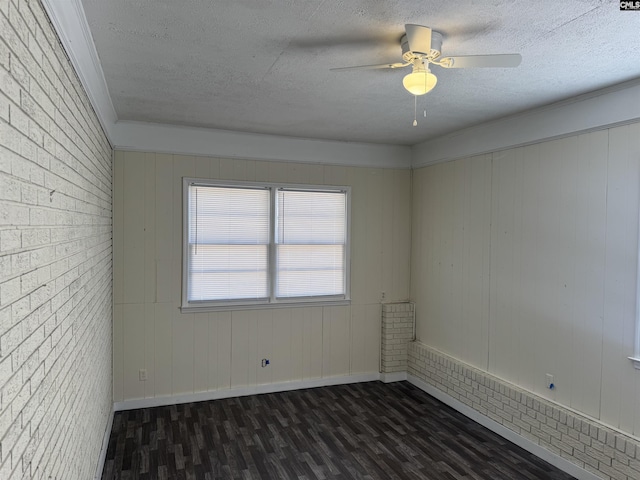 empty room featuring a textured ceiling, dark wood finished floors, a ceiling fan, and baseboards