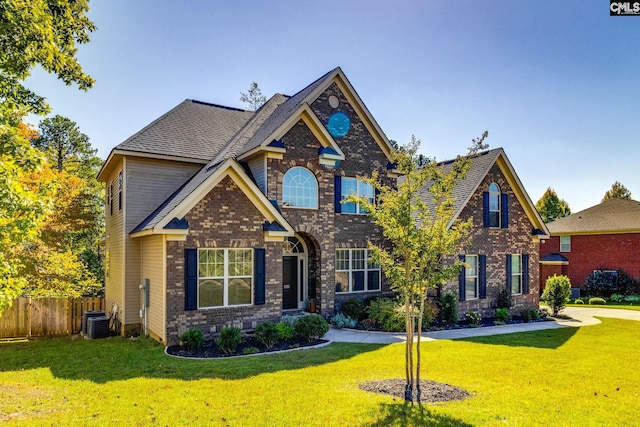 craftsman inspired home with a front yard, brick siding, and fence