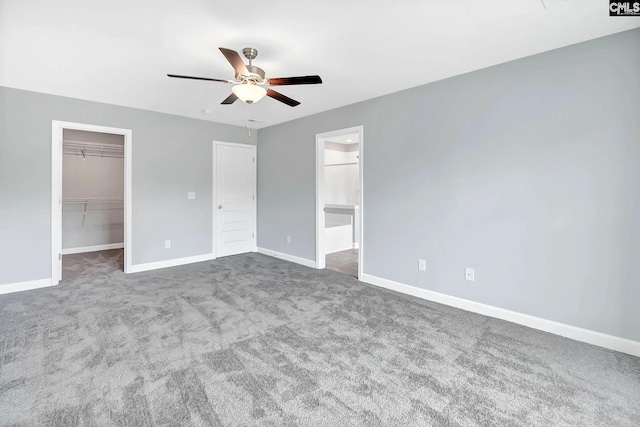 unfurnished bedroom with ceiling fan, carpet floors, baseboards, a spacious closet, and a closet