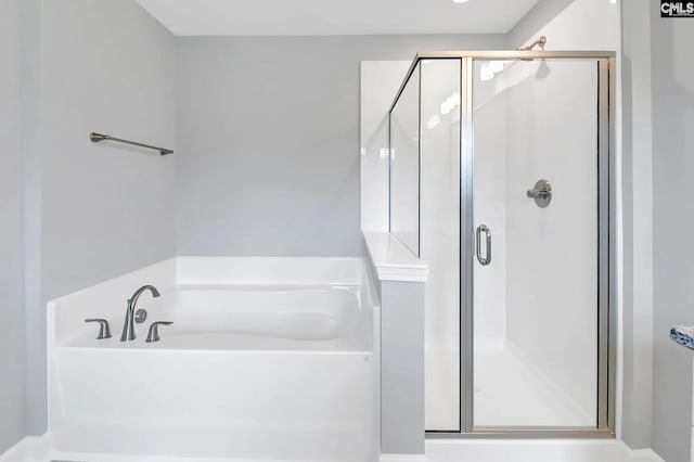 full bathroom featuring a stall shower and a garden tub