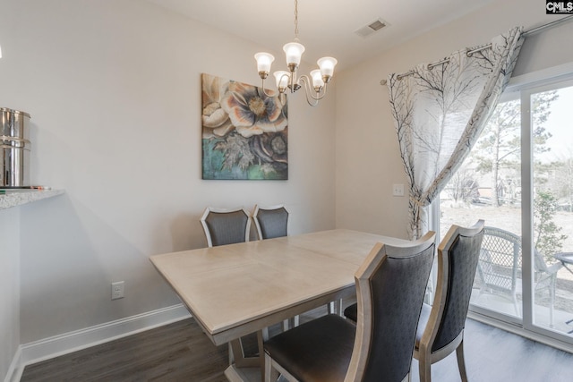 dining area with a notable chandelier, wood finished floors, visible vents, and baseboards