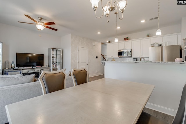 dining space featuring ceiling fan with notable chandelier, visible vents, dark wood-type flooring, and recessed lighting