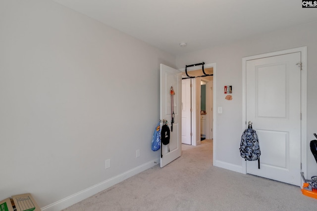 unfurnished bedroom with light carpet and baseboards