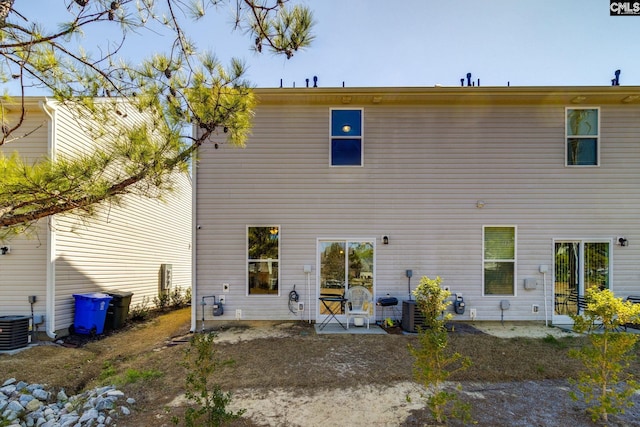 back of property with central AC and a patio