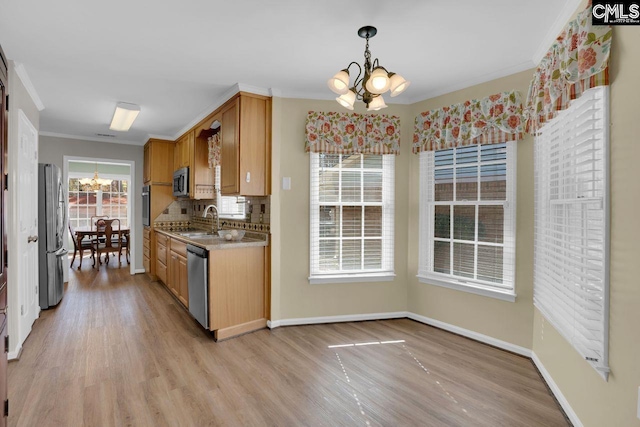 kitchen with tasteful backsplash, crown molding, a chandelier, light wood-type flooring, and appliances with stainless steel finishes