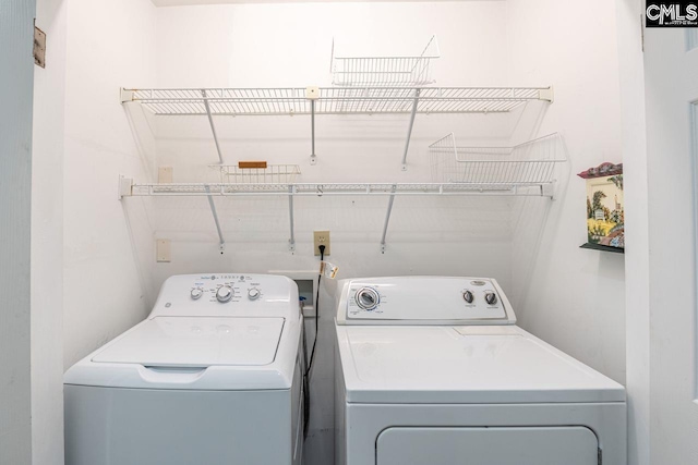 clothes washing area with washing machine and dryer and laundry area