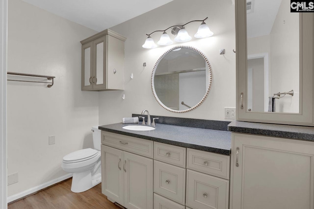 full bath with vanity, toilet, wood finished floors, and visible vents