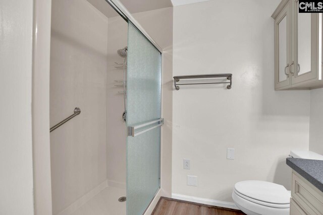 full bathroom with a shower stall, vanity, and wood finished floors