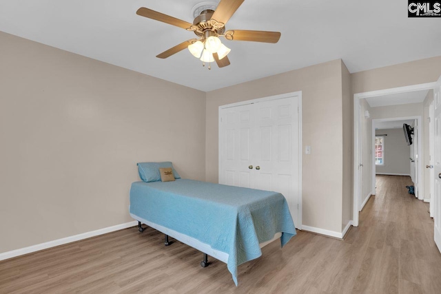 bedroom with baseboards, light wood-style floors, and a ceiling fan