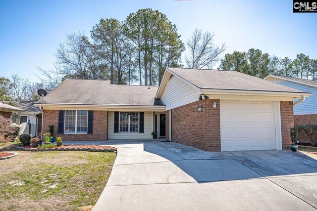 ranch-style home featuring a garage, a front yard, brick siding, and driveway
