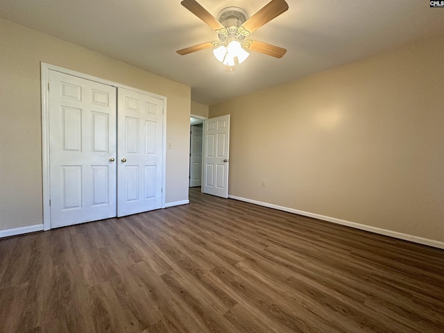 unfurnished bedroom with a closet, a ceiling fan, baseboards, and dark wood-style flooring