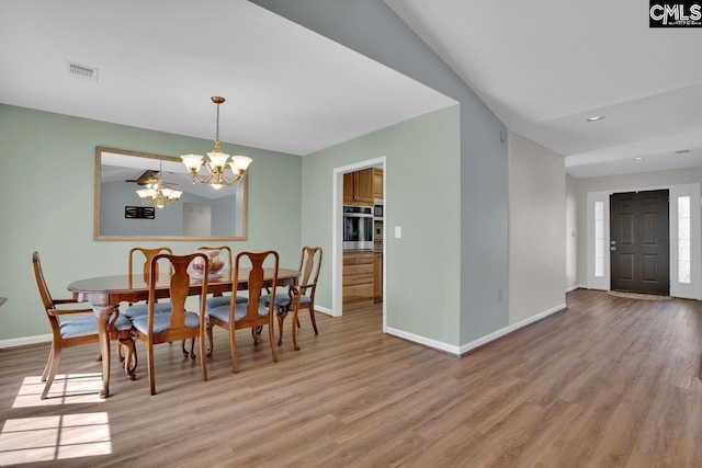 dining space with visible vents, baseboards, a chandelier, and light wood finished floors